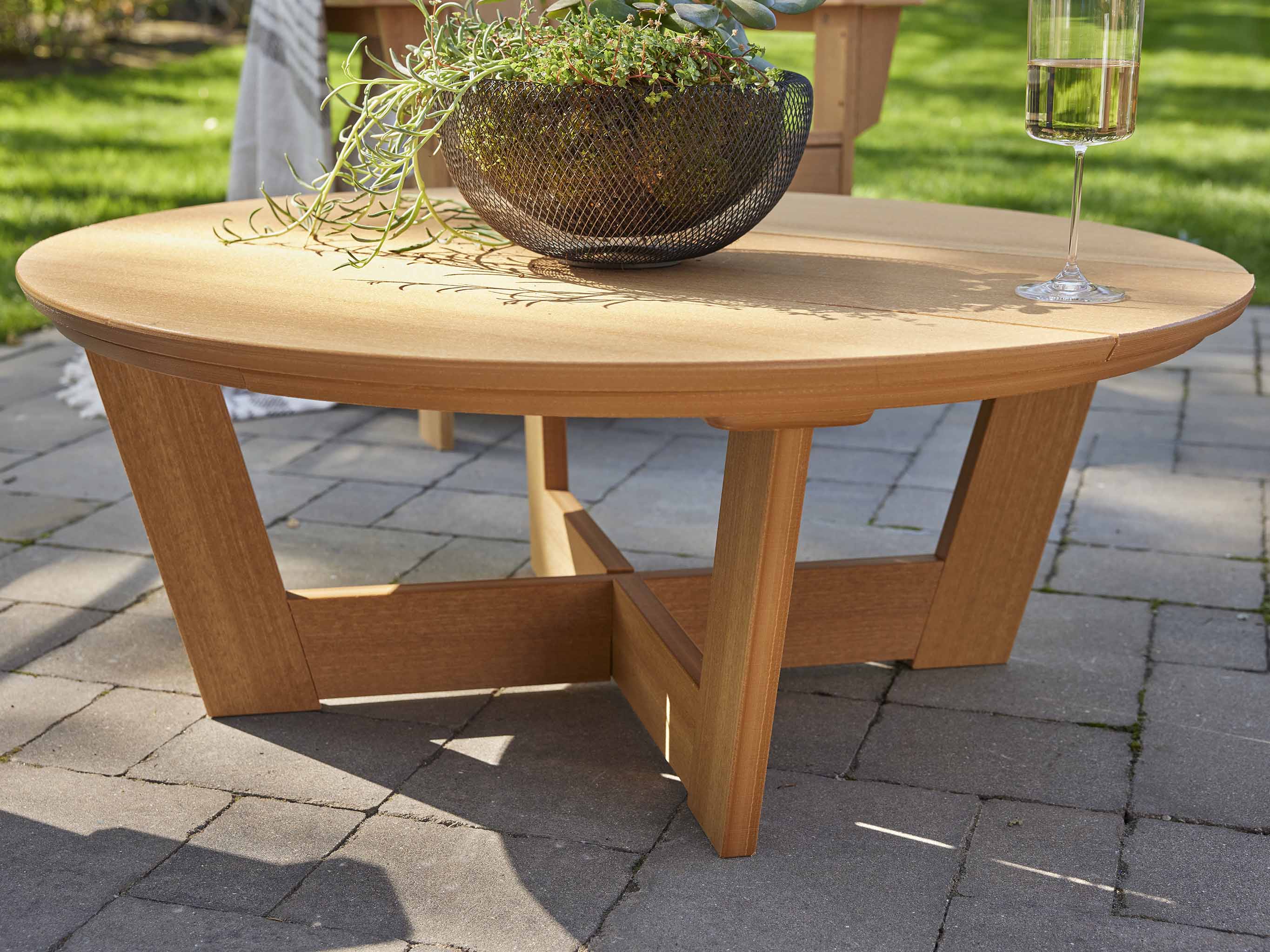 Natural Teak Cannon Beach Conversation Table with wine glass on stone patio