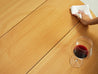 Red wine in a glass on a table with a hand wiping with a cloth