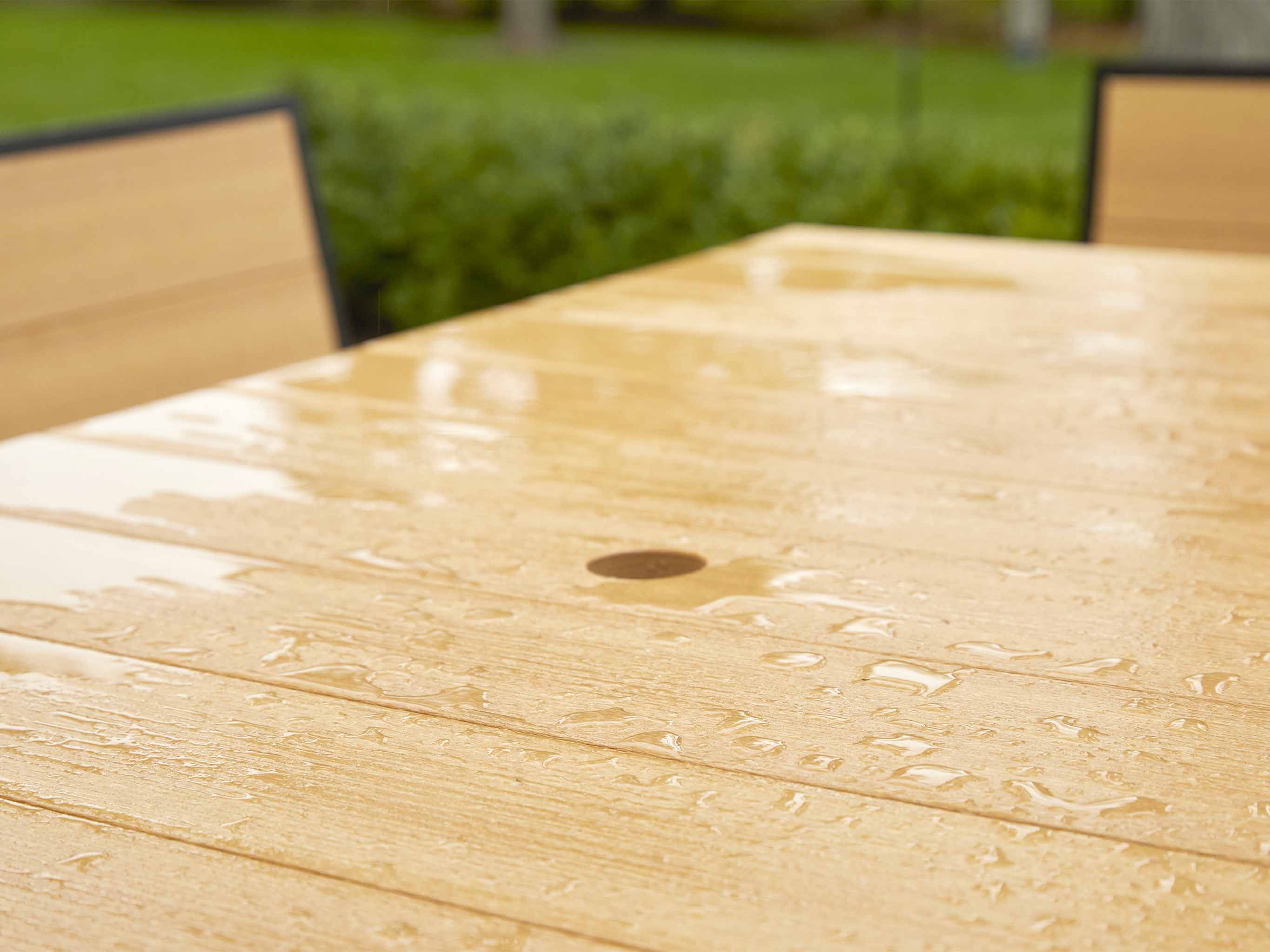 Water droplets on Natural Teak table with umbrella hole